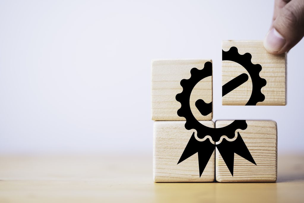 Closeup of hand putting to assemble quality assurance icon which